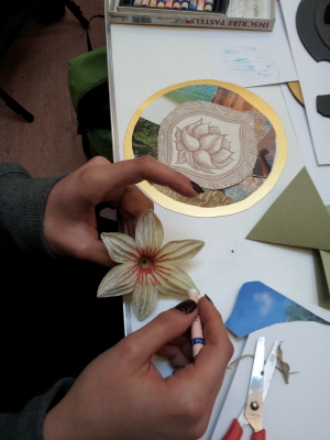 Person painting a flower in an artistic history workshop.